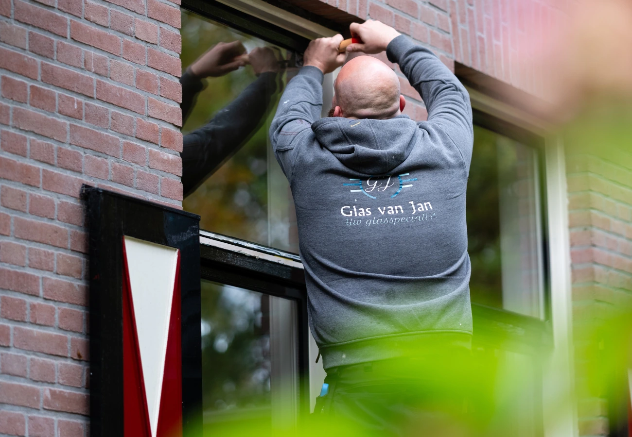 Glaszetter Hooglanderveen: monteur van Glas van Jan werkt aan een raamkozijn